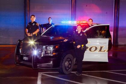 Police officers standing near vehicle.
