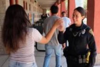 Highschool outreach student and officer high five 