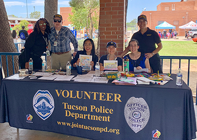 TPD volunteers outdoors at a school staffing a table